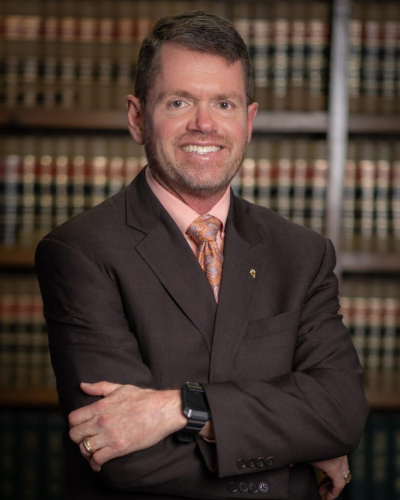 Jeffrey Vires legal attorney in Crossville Tennessee standing in front of a library of law books