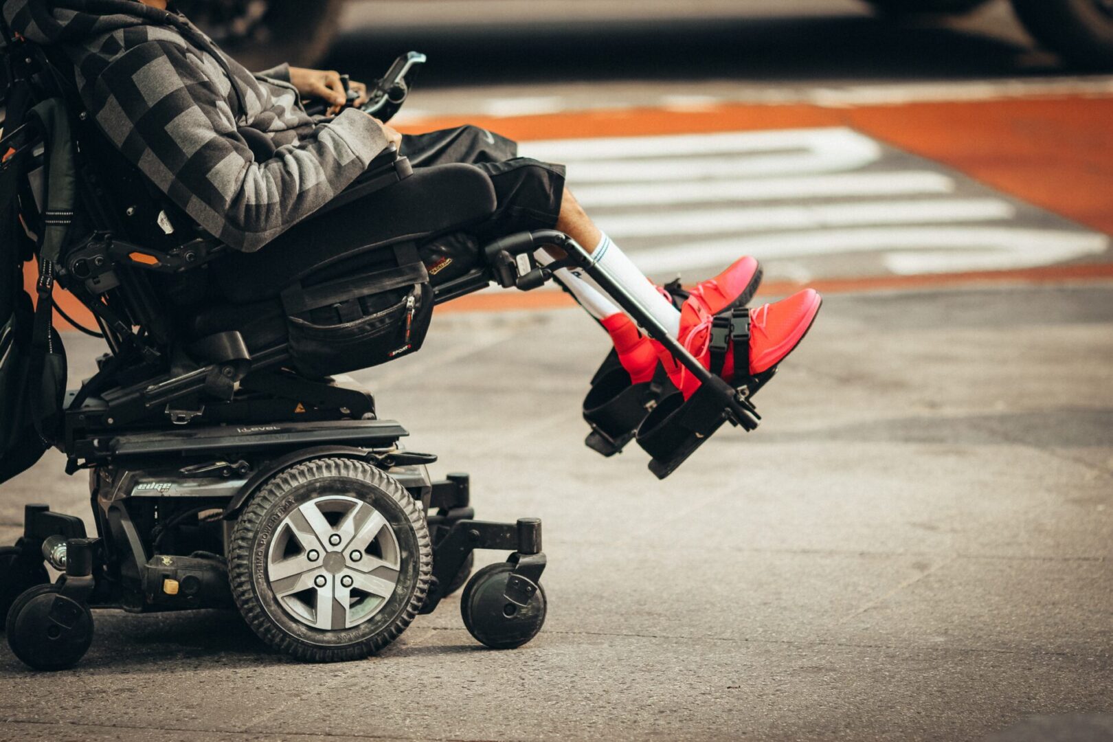 A man receiving Social Security Disability sitting in a wheelchair on a street.