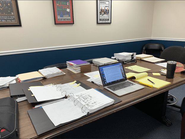 Attorney conference table with legal documents everywhere showing a mess preparing for a disability case