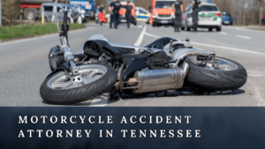 A crashed motorcycle lying on the road and a written text of "Motorcycle Accident Attorney in Tennessee"